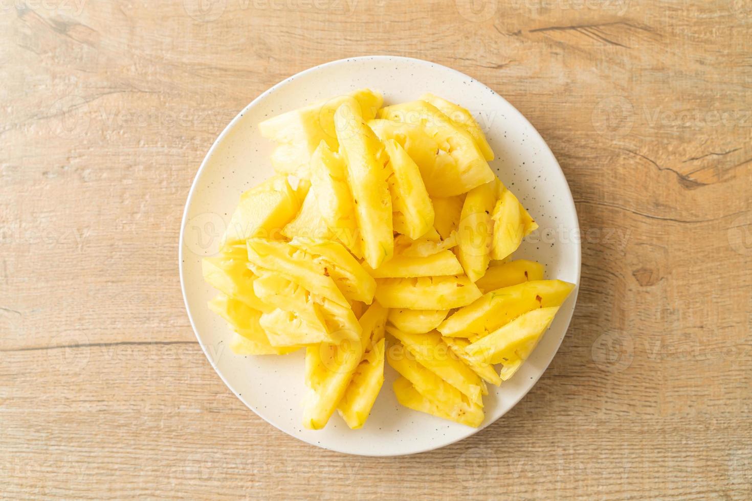 Fresh pineapple sliced on white plate photo