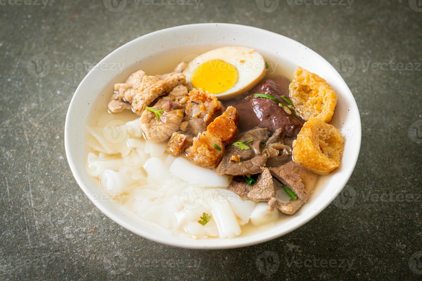 Paste of rice flour or boiled Chinese pasta square with pork in brown soup - Asian food style photo