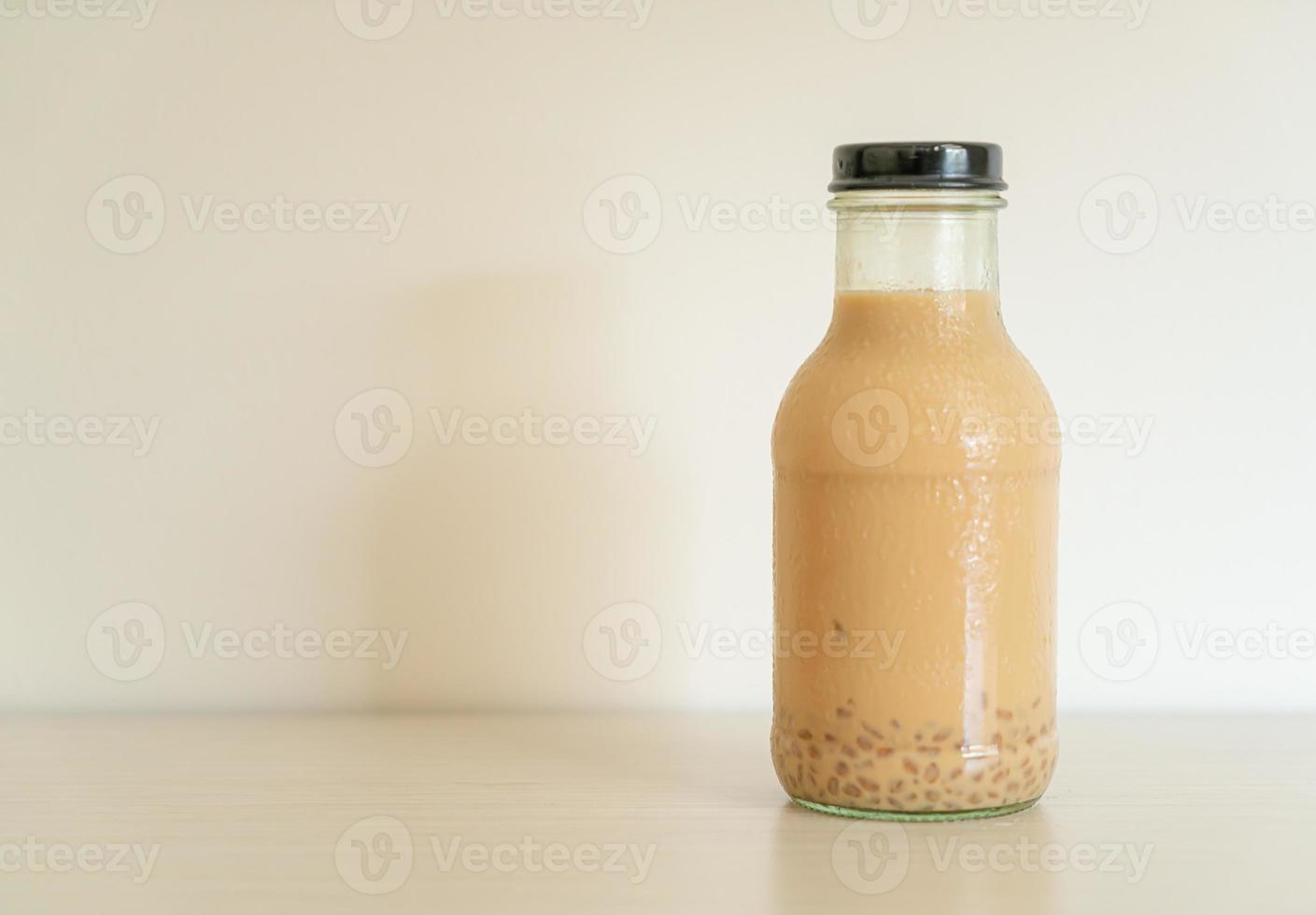 Té con leche con gelatina de pudín en botella de vidrio sobre la mesa foto