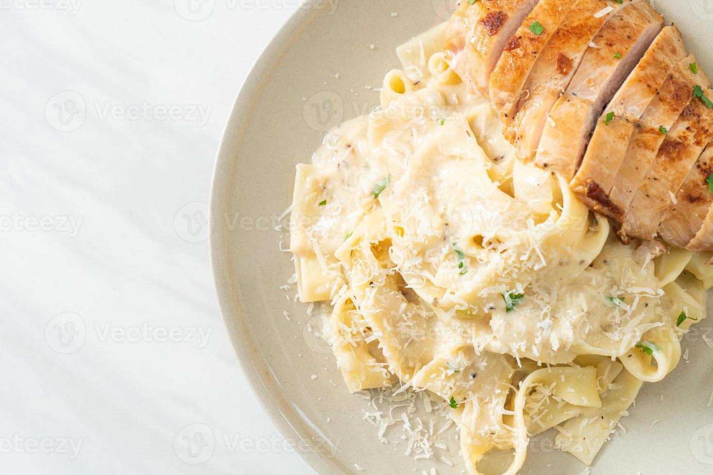 Pasta fettucine casera salsa cremosa blanca con pollo a la parrilla foto