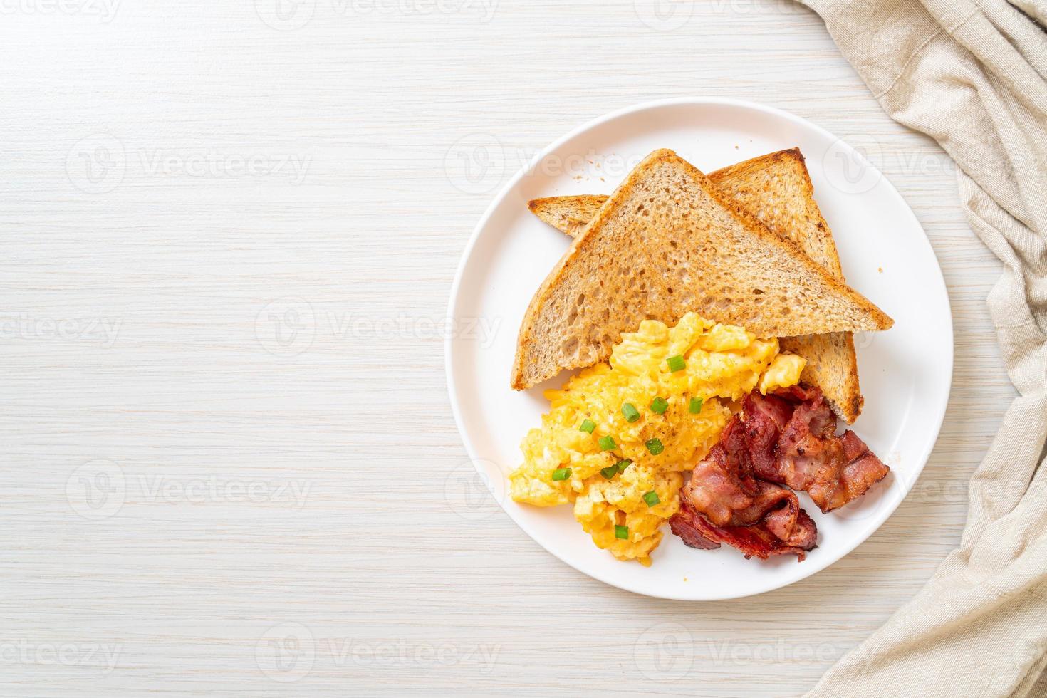 Scrambled egg with bread toasted and bacon for breakfast photo