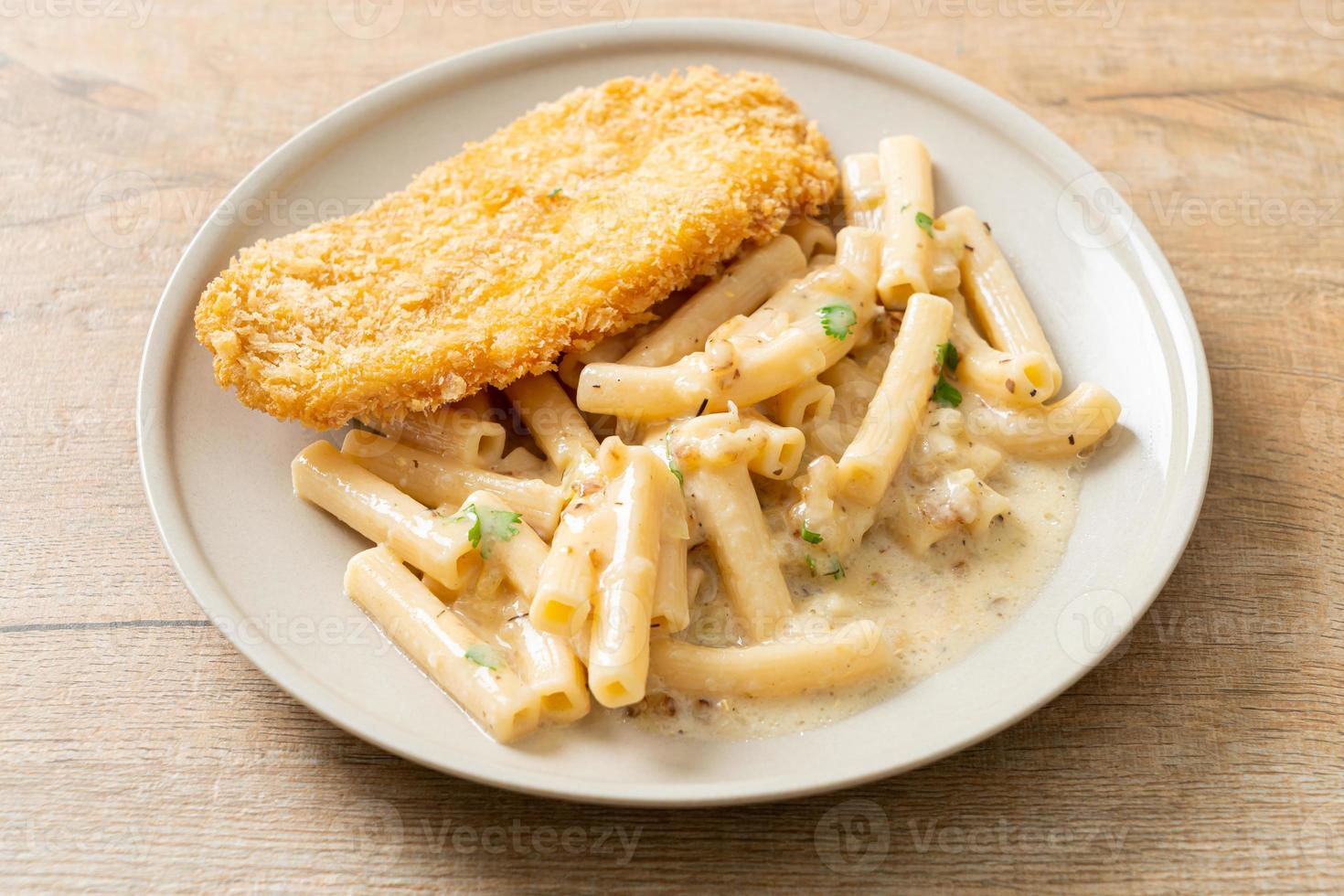 Pasta casera quadrotto penne salsa de crema blanca con pescado frito foto