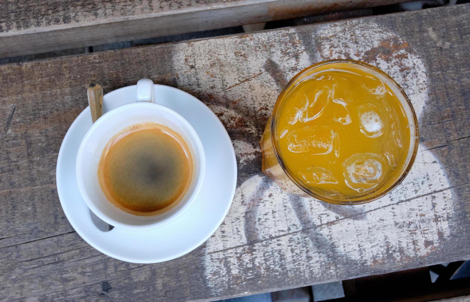 taza de café y un vaso de jugo de naranja fresco en una tabla de madera foto