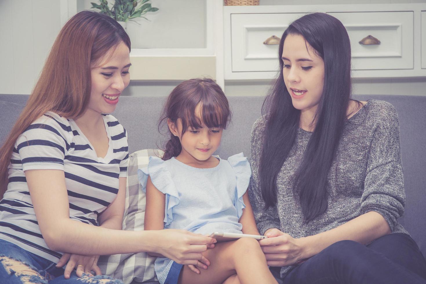 Mother, Aunt and kid having time together lerning with using tablet photo