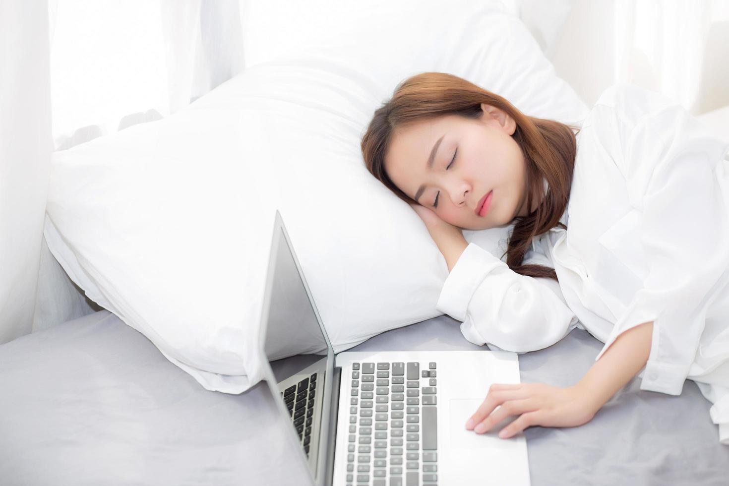 joven, mujer asiática, con, computador portatil, acostado, en, dormitorio foto