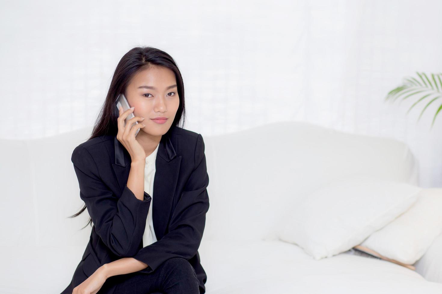 Young asian woman talking phone in the living room photo