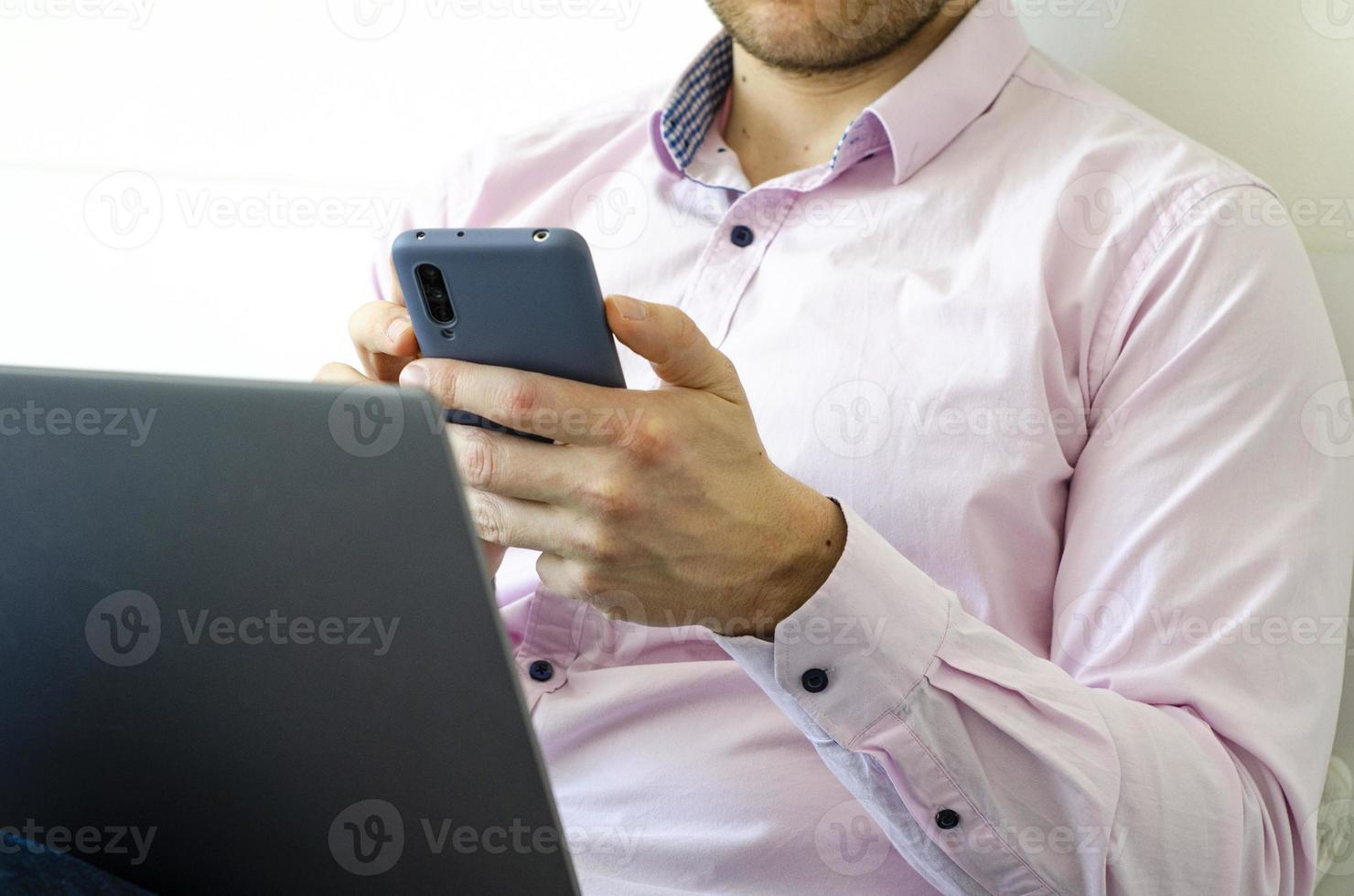 A man in a shirt and jeans solves work issues remotely. photo