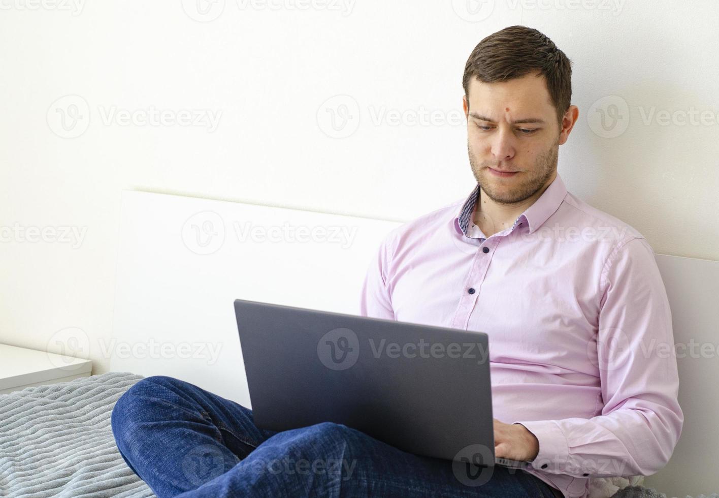 A man in a shirt and jeans solves work issues remotely. photo