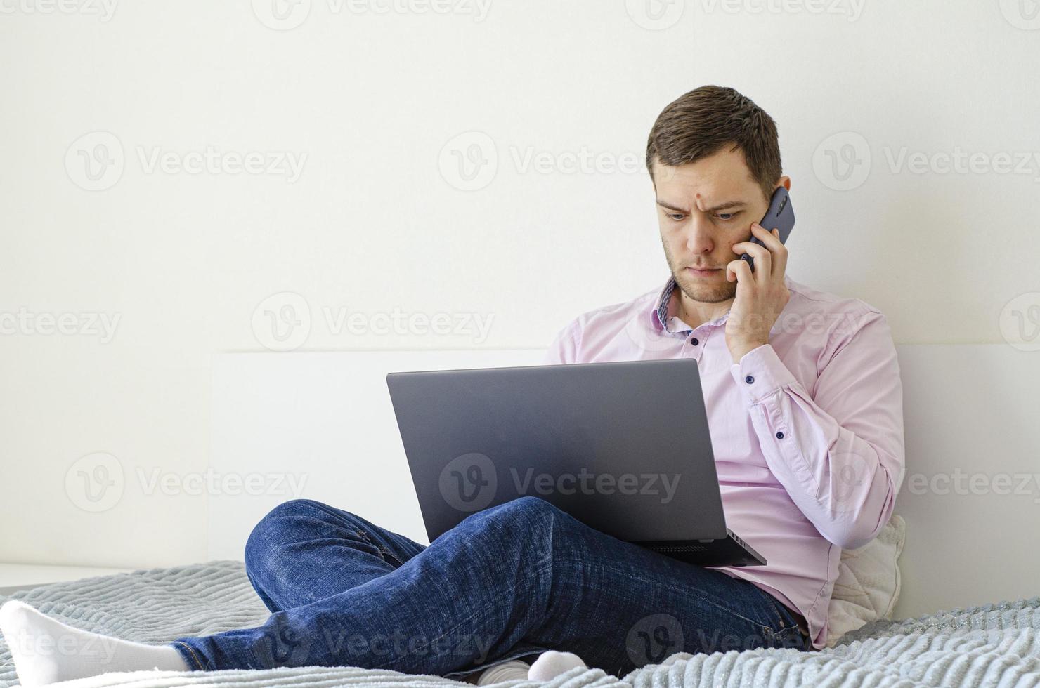 A man in a shirt and jeans solves work issues remotely. photo