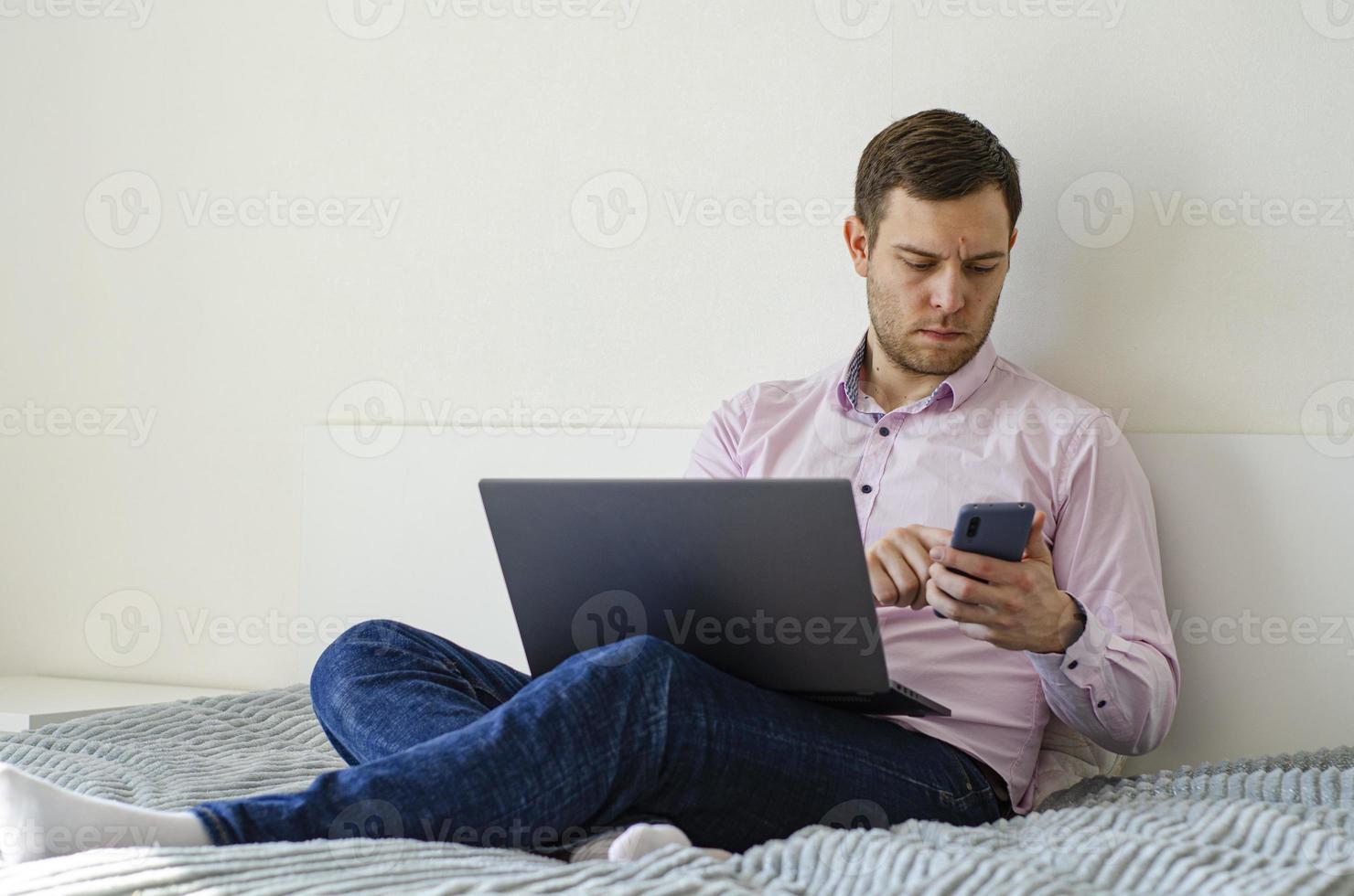 A man in a shirt and jeans solves work issues remotely. photo