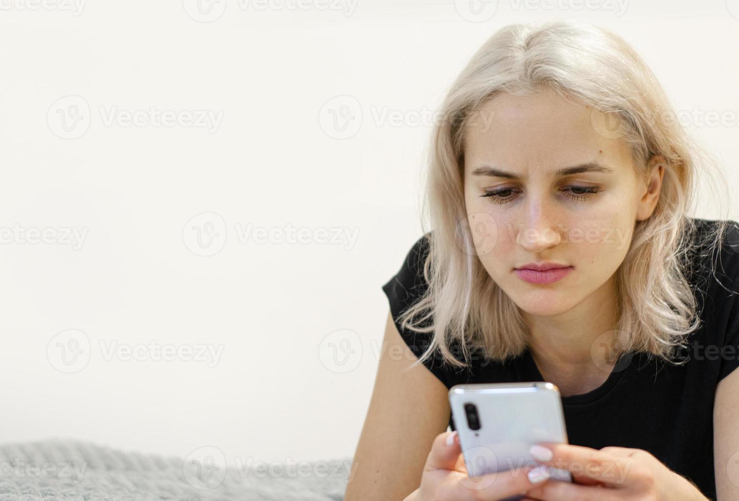 The girl reads bad news on the phone. Social networks. photo