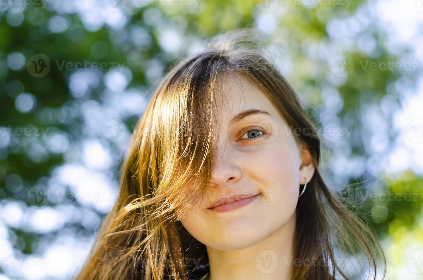 hermosa chica, cabello castaño. sonríe. bosque, verano. foto