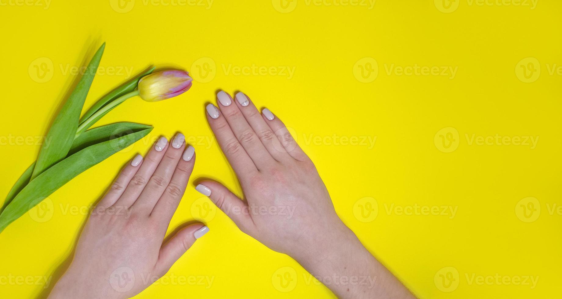 manicura femenina sobre un fondo brillante. amarillo foto