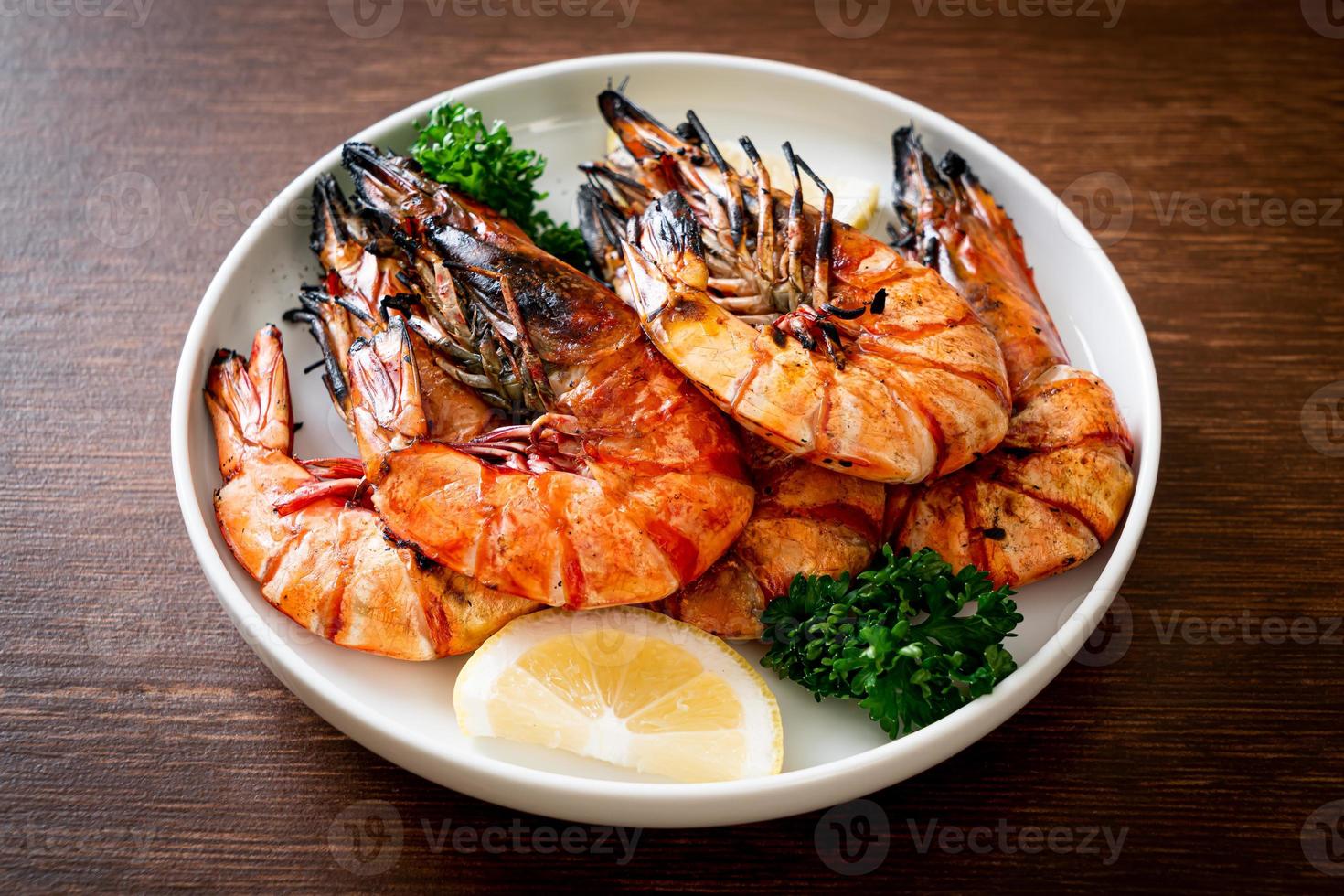 Grilled tiger prawns or shrimps with lemon on plate photo