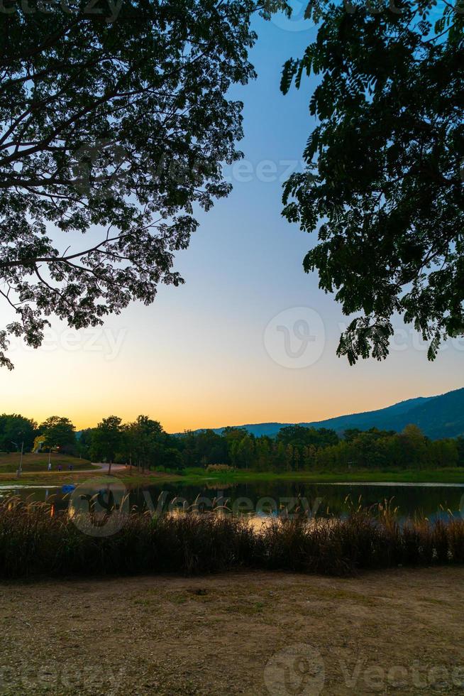 Beautiful lake at Chiang Mai with forested mountain and twilight sky in Thailand. photo