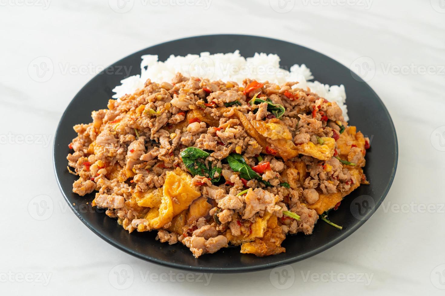 Stirfried minced pork with basil and egg topped on rice Asian food