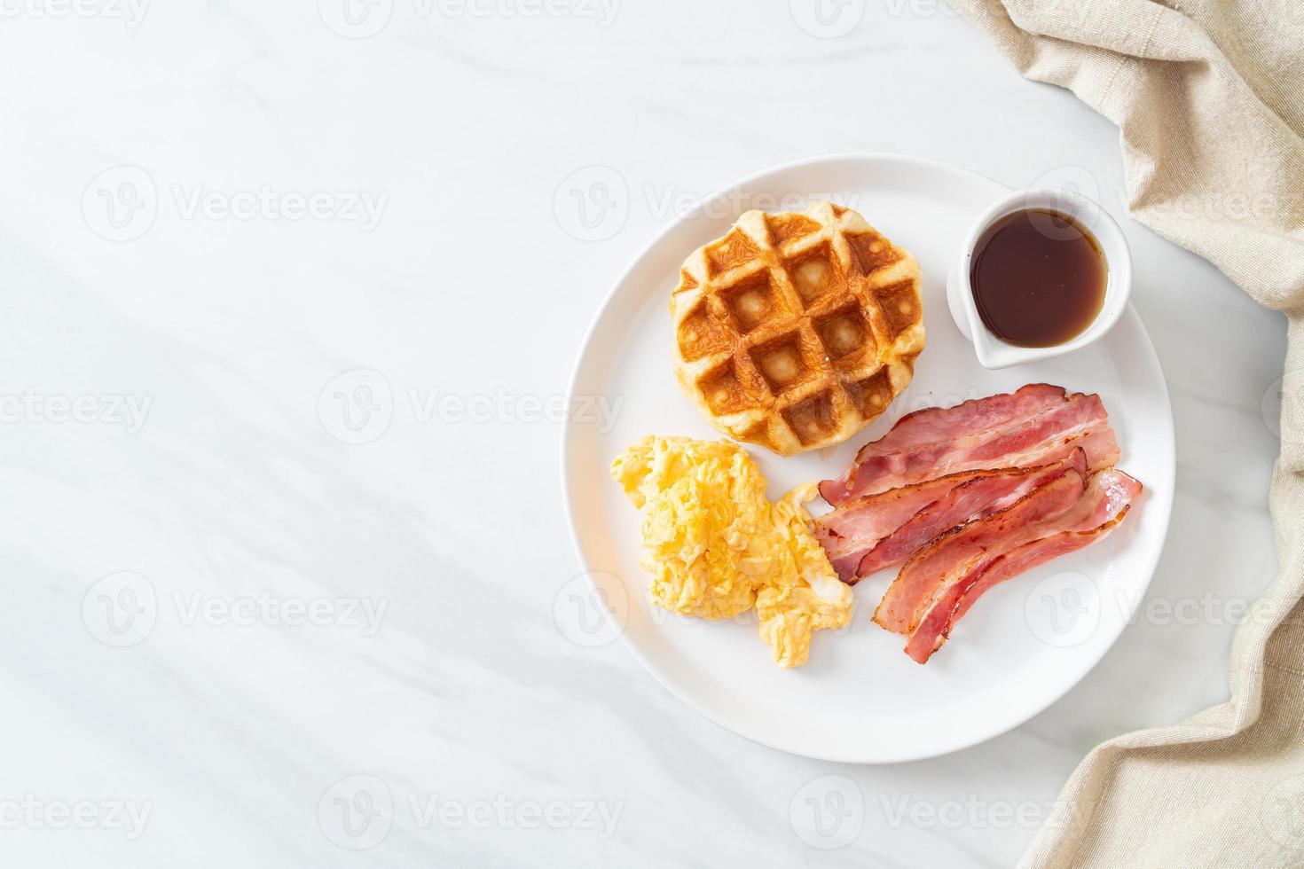 huevos revueltos con tocino y waffle para desayunar foto