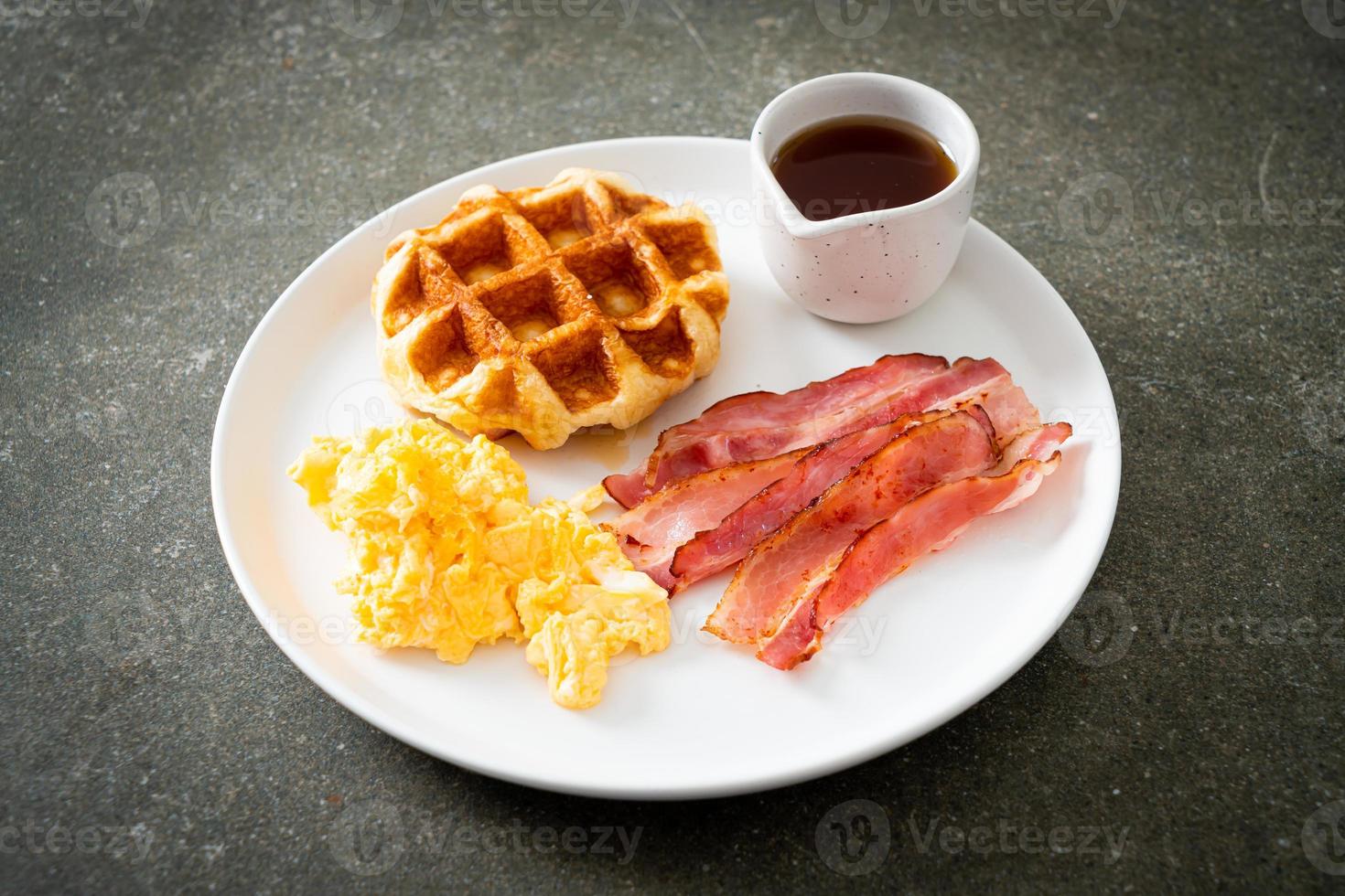 huevos revueltos con tocino y waffle para desayunar foto