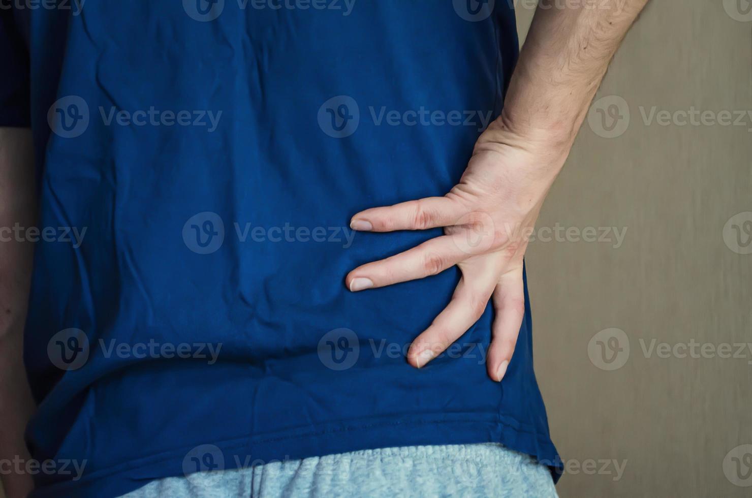 A man holding his back. Back pain. photo