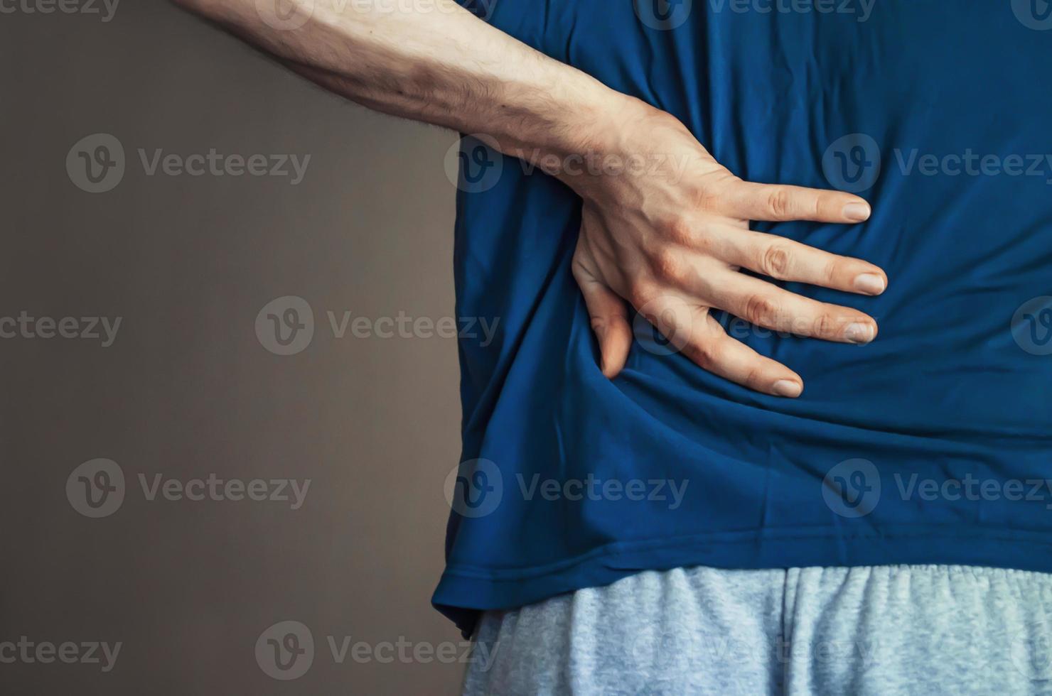 un hombre sosteniendo su espalda. dolor de espalda. foto