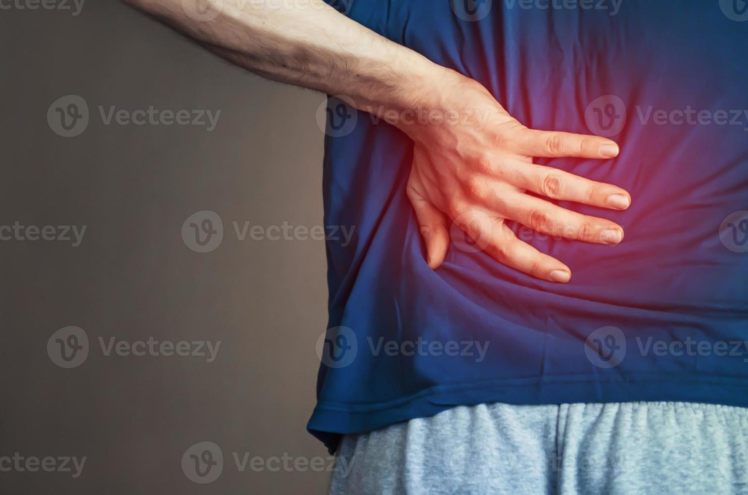 A man holding his back. Back pain. photo