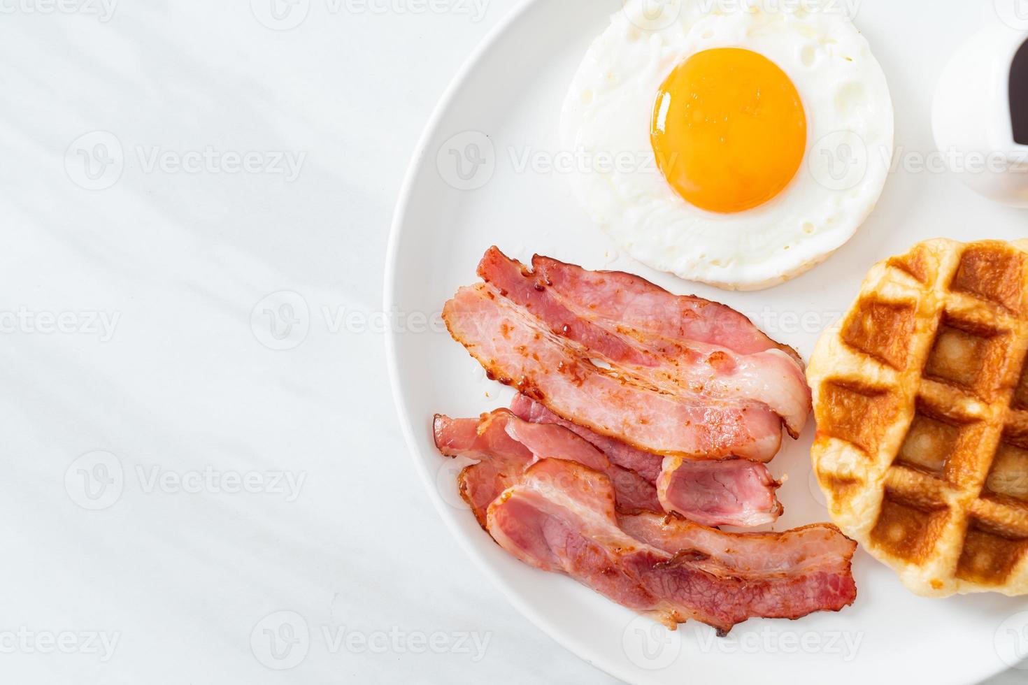 Fried egg with bacon and waffle for breakfast photo