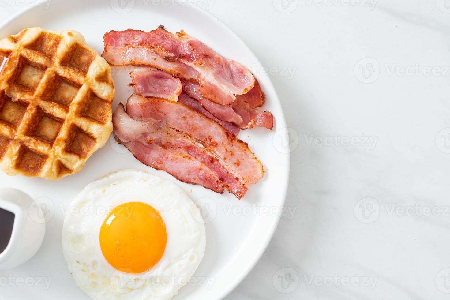 Fried egg with bacon and waffle for breakfast photo