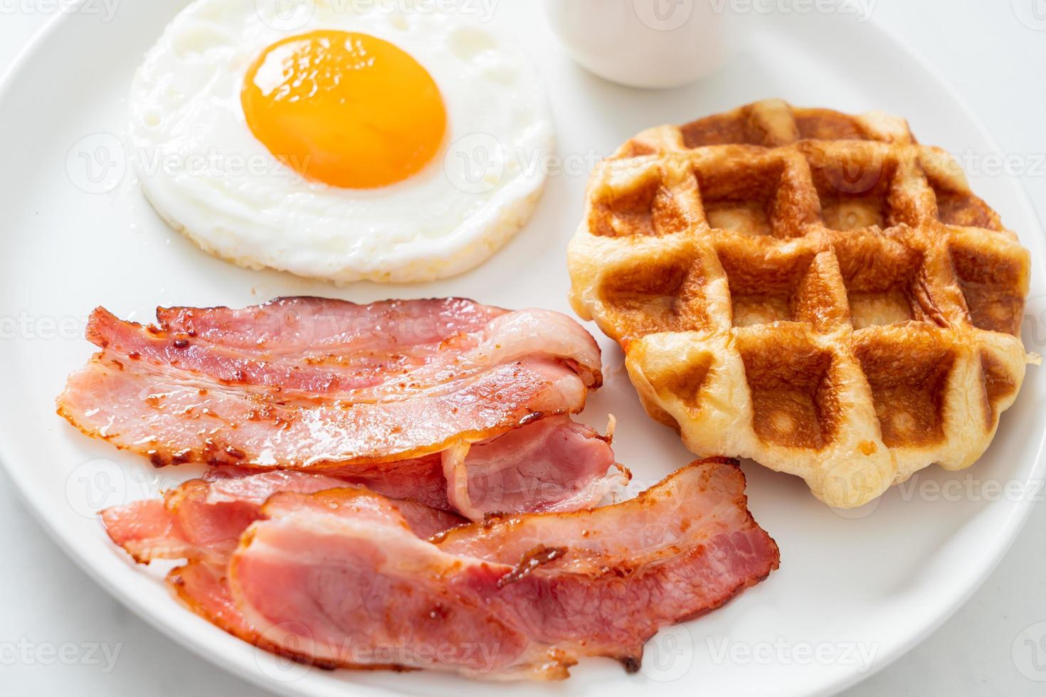 Fried egg with bacon and waffle for breakfast photo