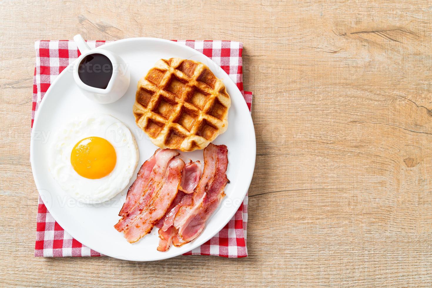 Fried egg with bacon and waffle for breakfast photo