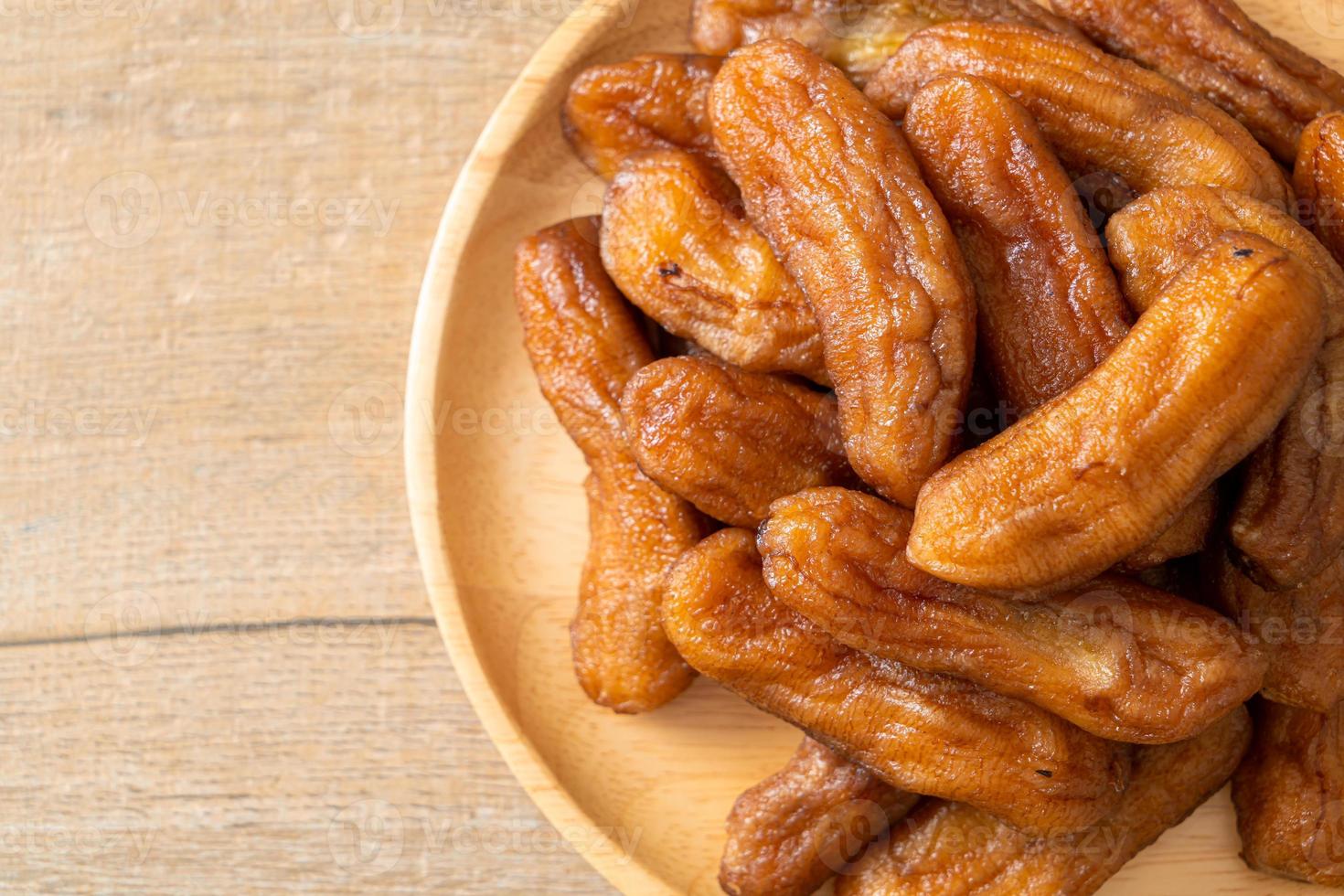 Sun-dried banana on wooden plate photo