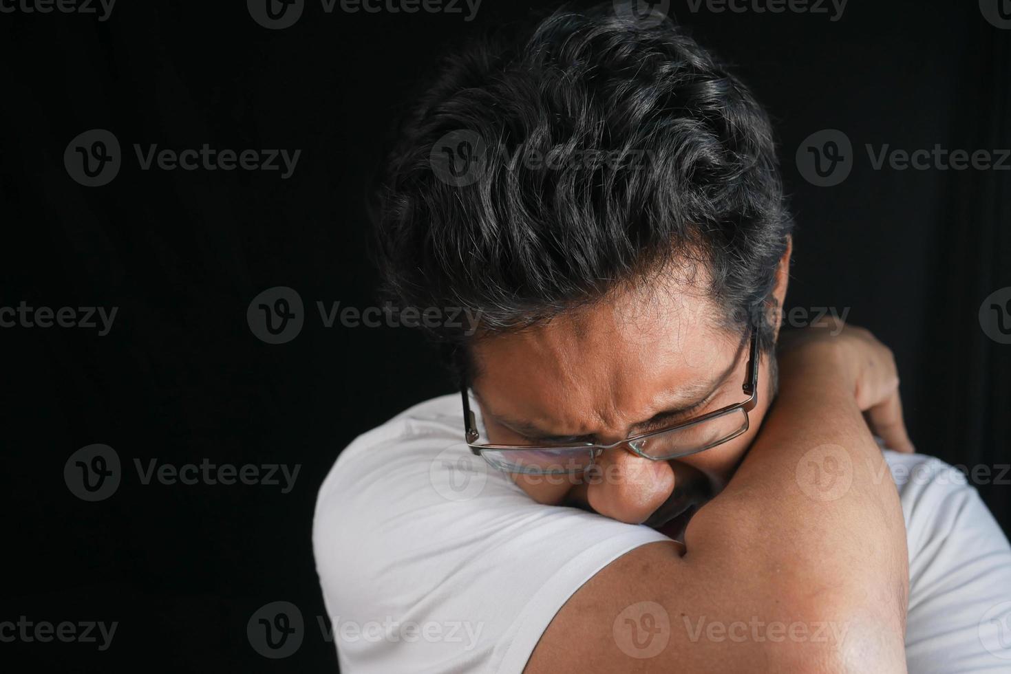 joven enfermo tapándose la nariz y la boca con el brazo. foto