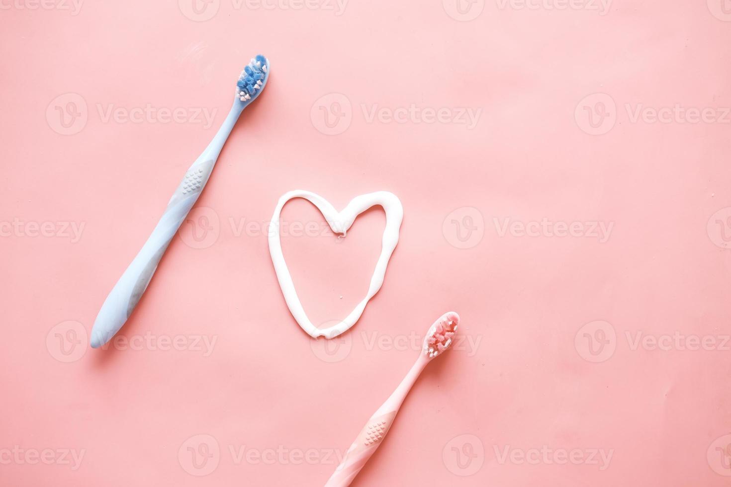 tooth brush and paste on pink background photo