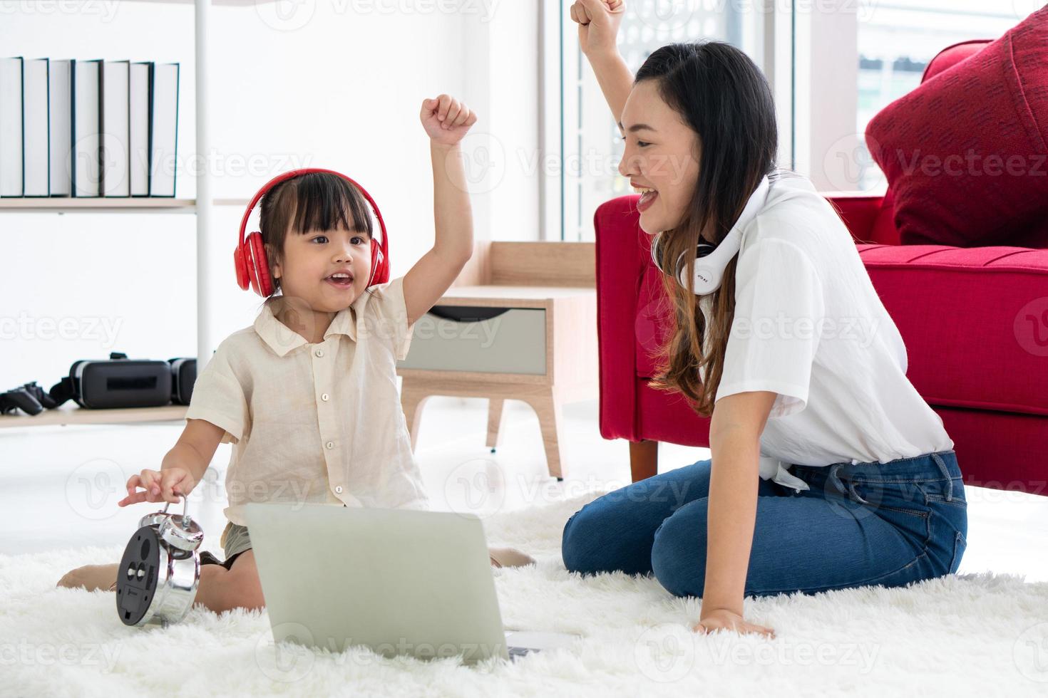 asian mother with teaching child to study from computer at home photo