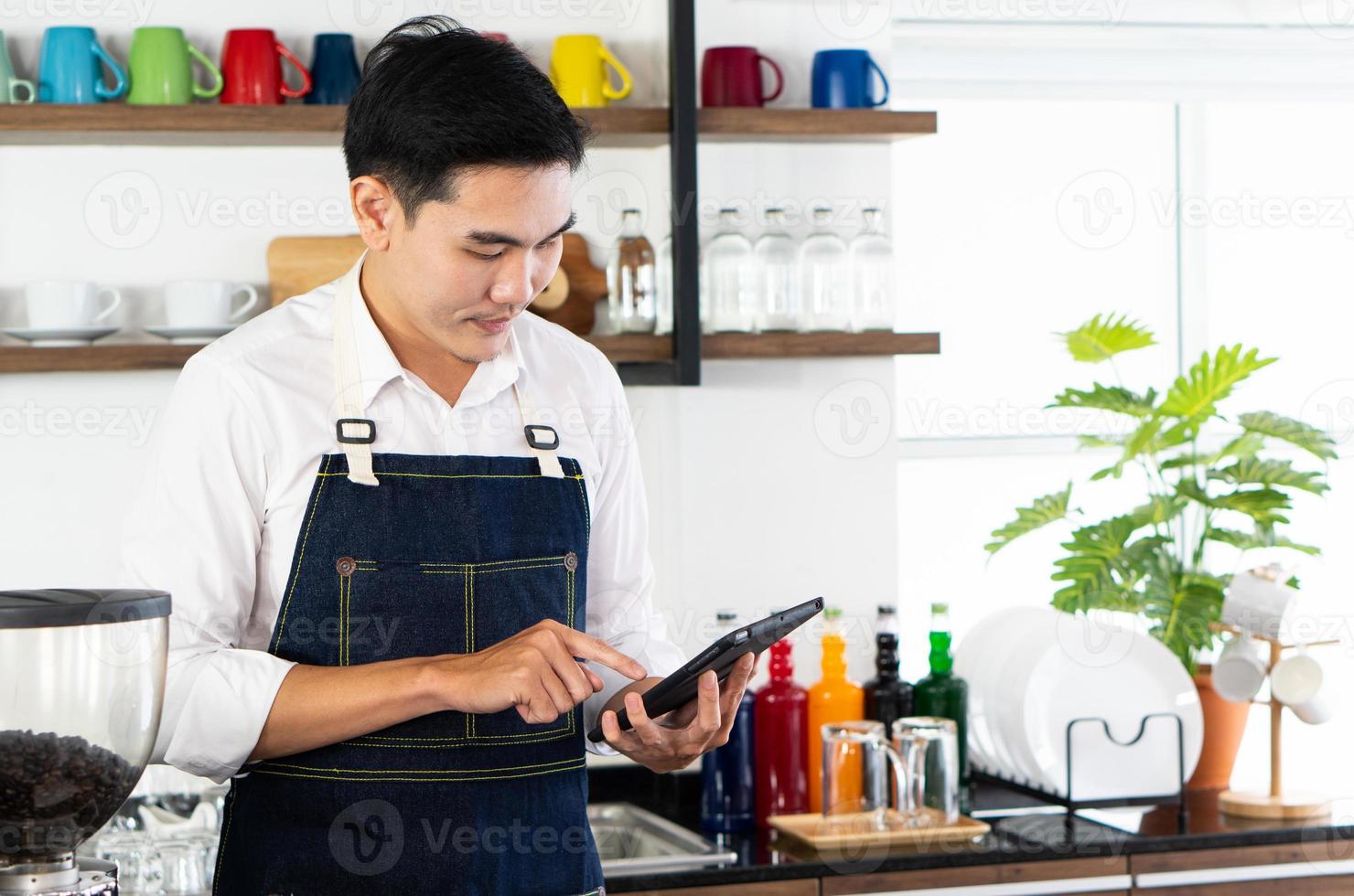 Joven barista asiático tomando el pedido de café en el café foto