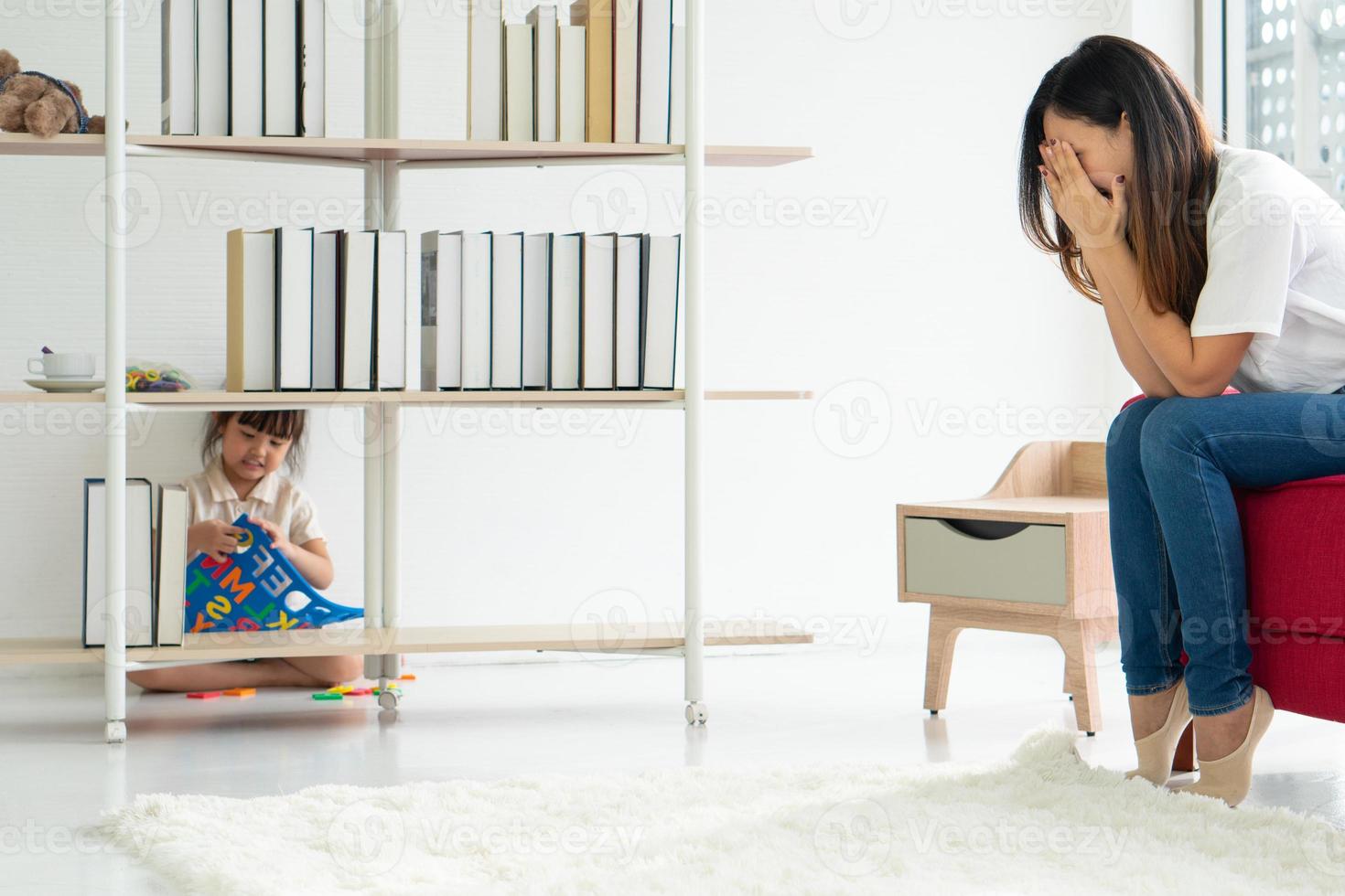 Niño asiático jugando al escondite con los padres en casa foto