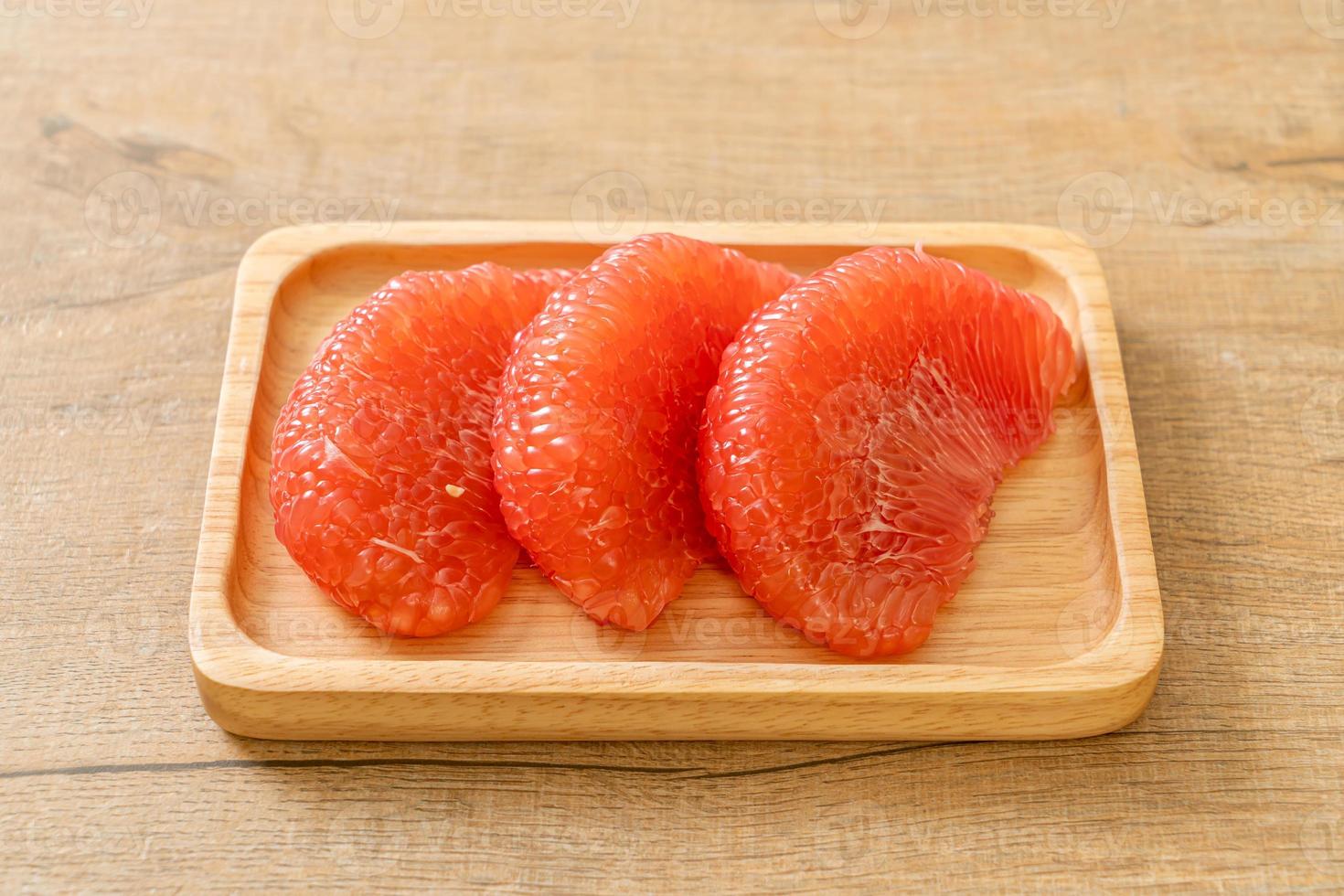 Fresh red pomelo fruit or grapefruit on plate photo