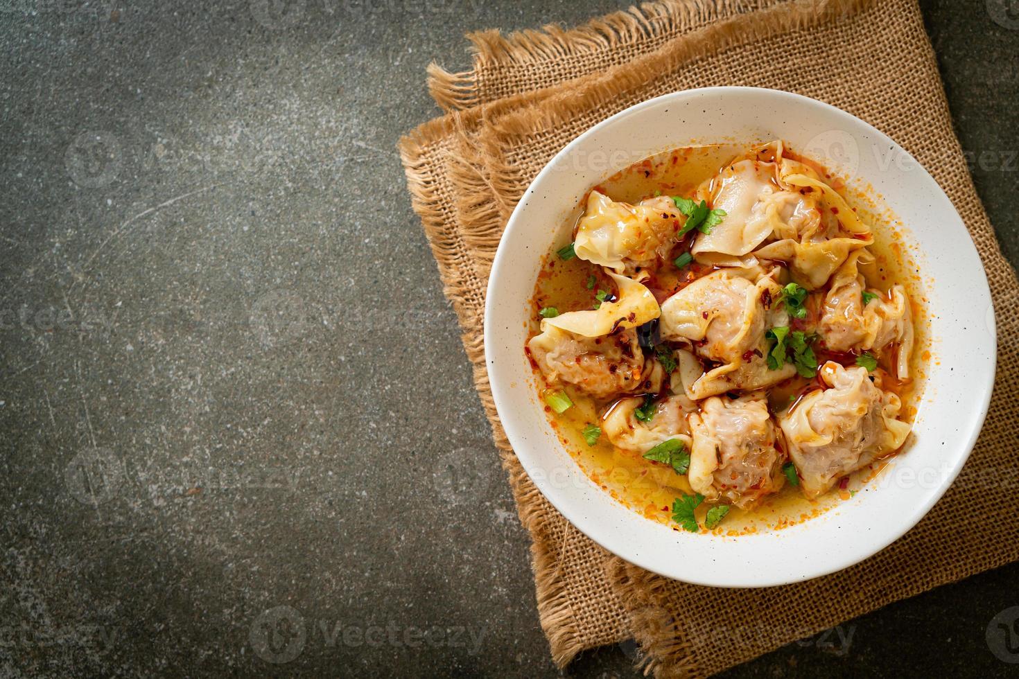 sopa de wonton de cerdo o sopa de albóndigas de cerdo con chile asado - estilo de comida asiática foto