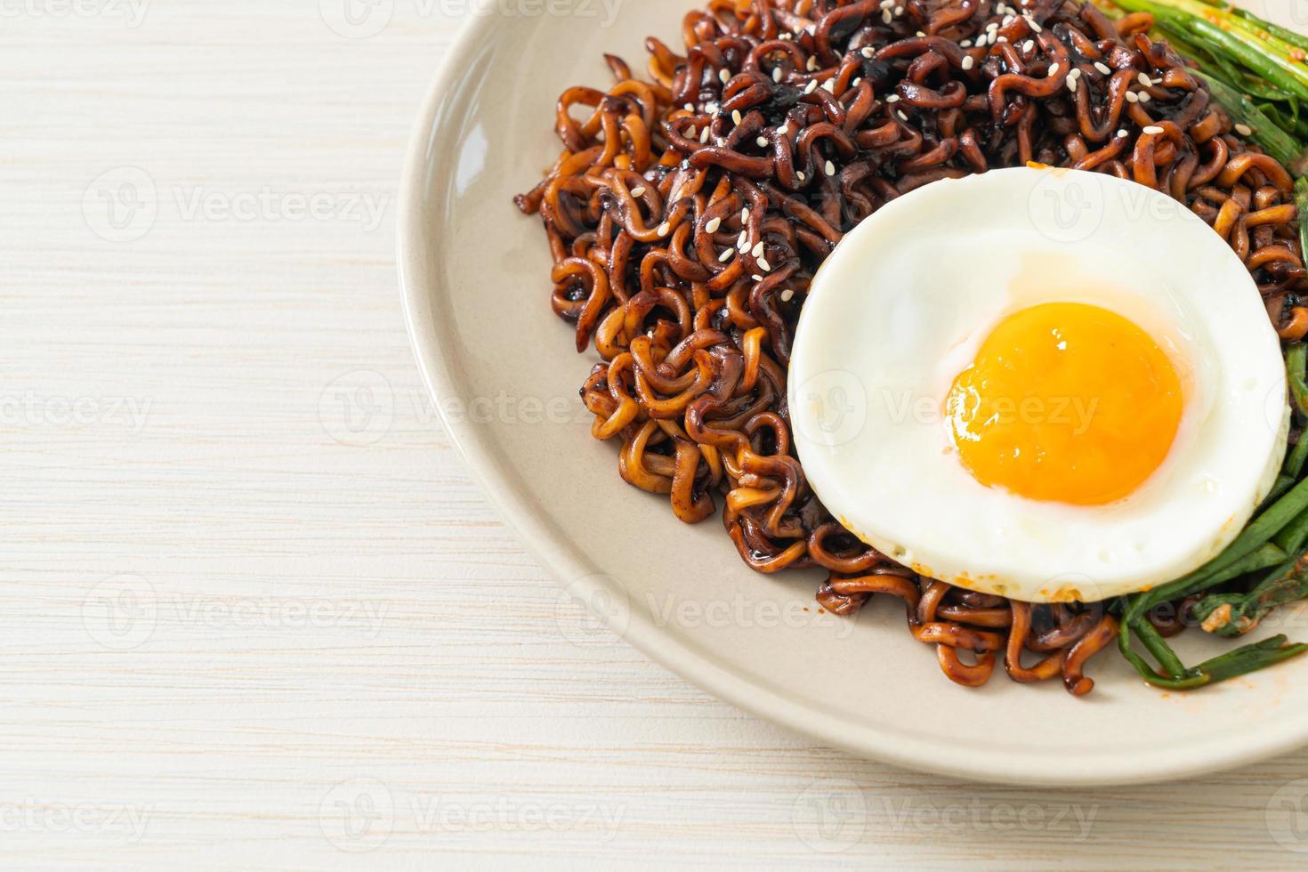 Homemade dried Korean spicy black sauce instant noodles with fried egg and kimchi photo