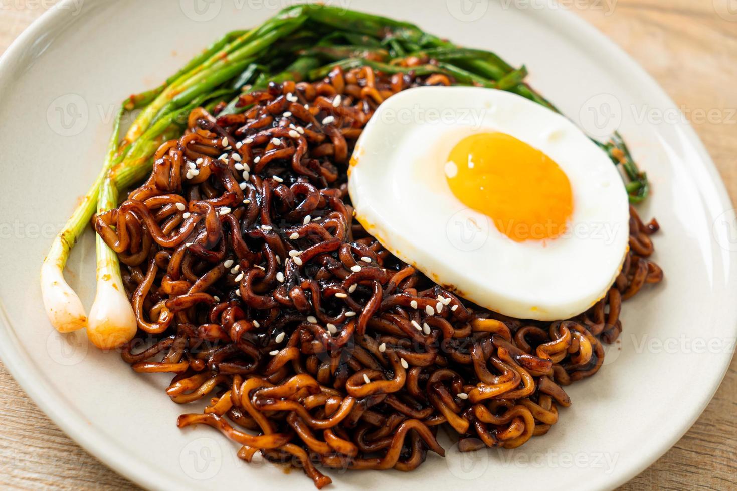 Homemade dried Korean spicy black sauce instant noodles with fried egg and kimchi photo