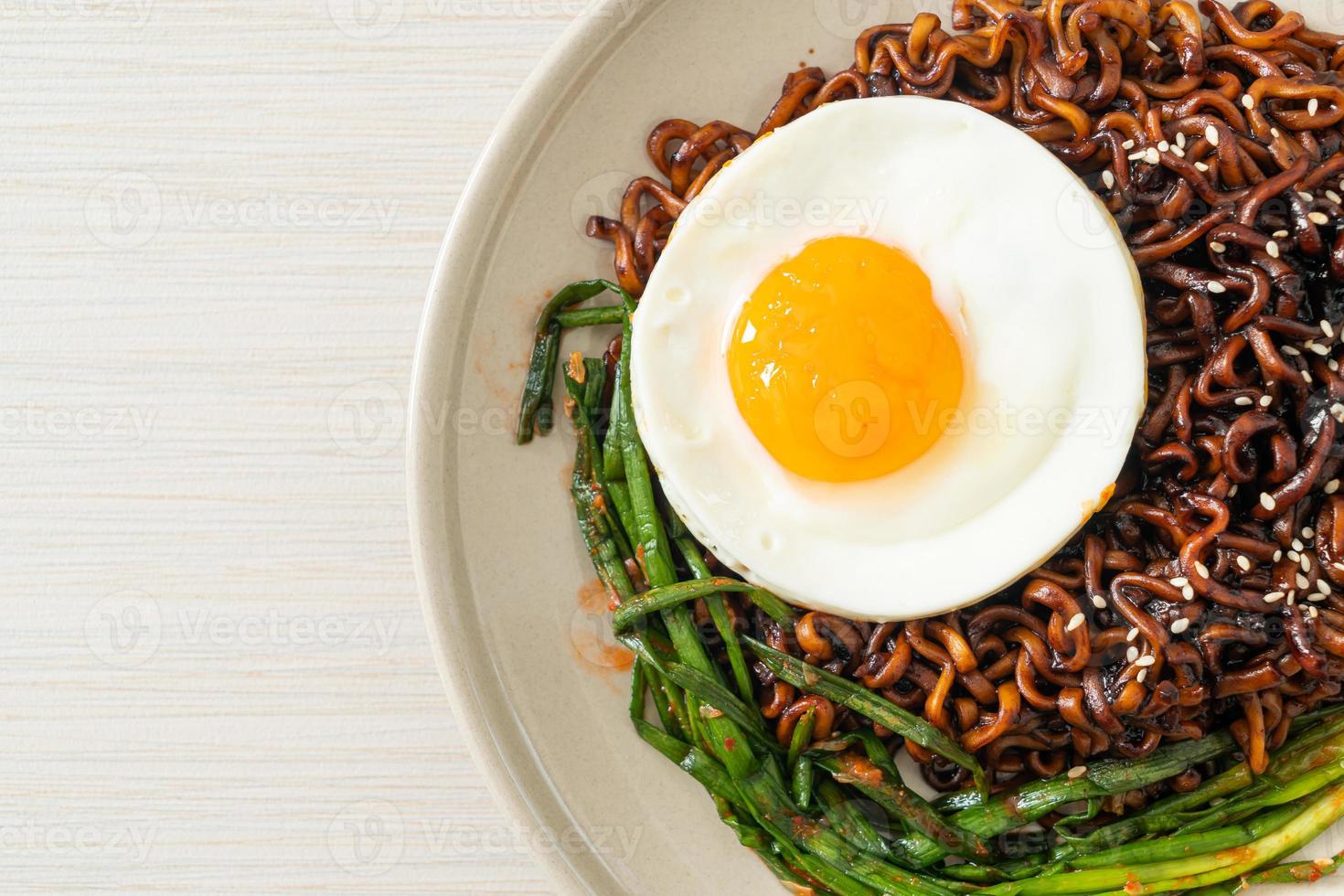 Homemade dried Korean spicy black sauce instant noodles with fried egg and kimchi photo