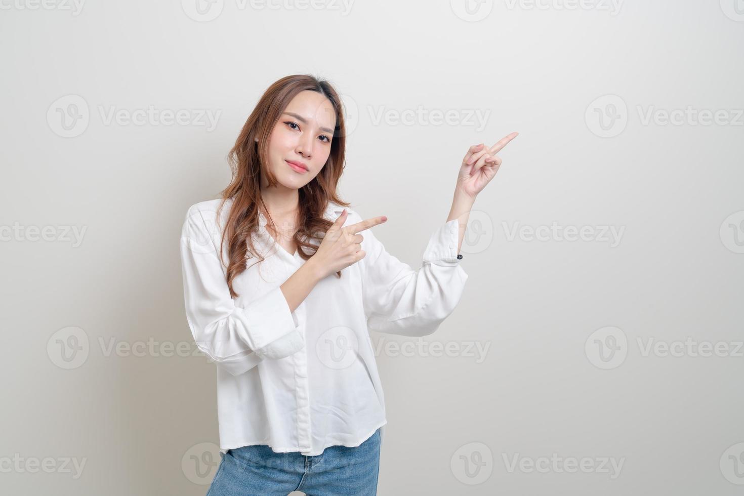 Retrato hermosa mujer asiática con la mano presentando o apuntando sobre fondo blanco. foto