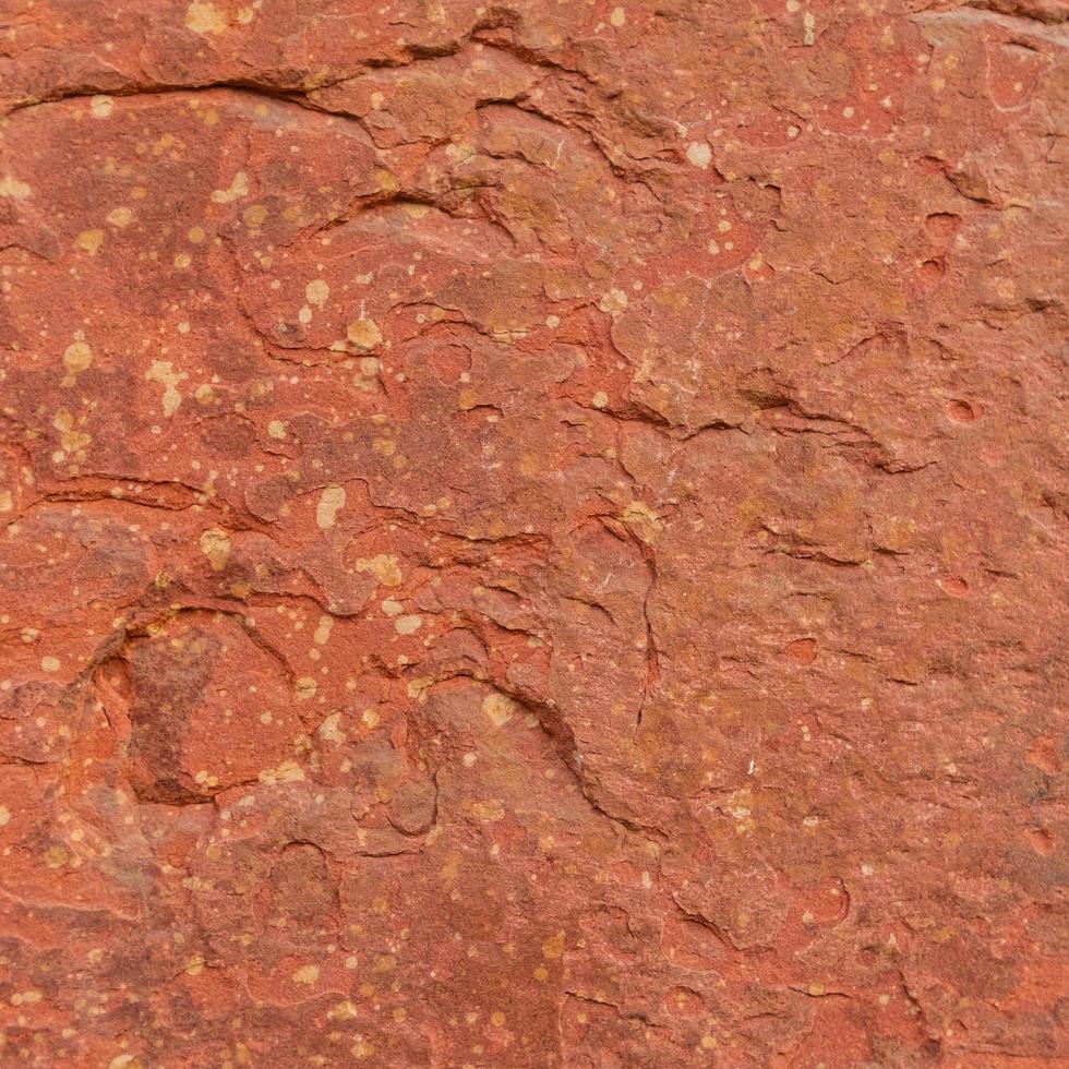 Fondo de textura de piedra rugosa roja. foto