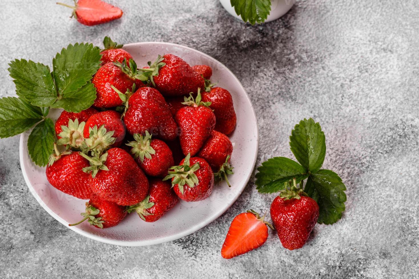 Hermosas fresas frescas jugosas en la superficie de hormigón foto