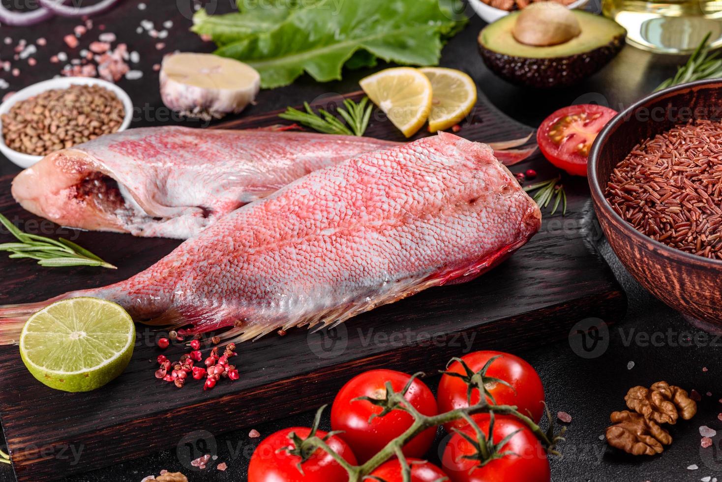 Raw fillet of red sea perch prepared for baking with spices and herbs photo