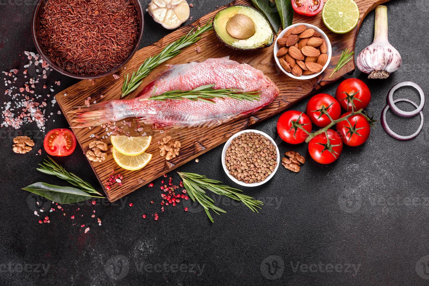 Raw fillet of red sea perch prepared for baking with spices and herbs photo