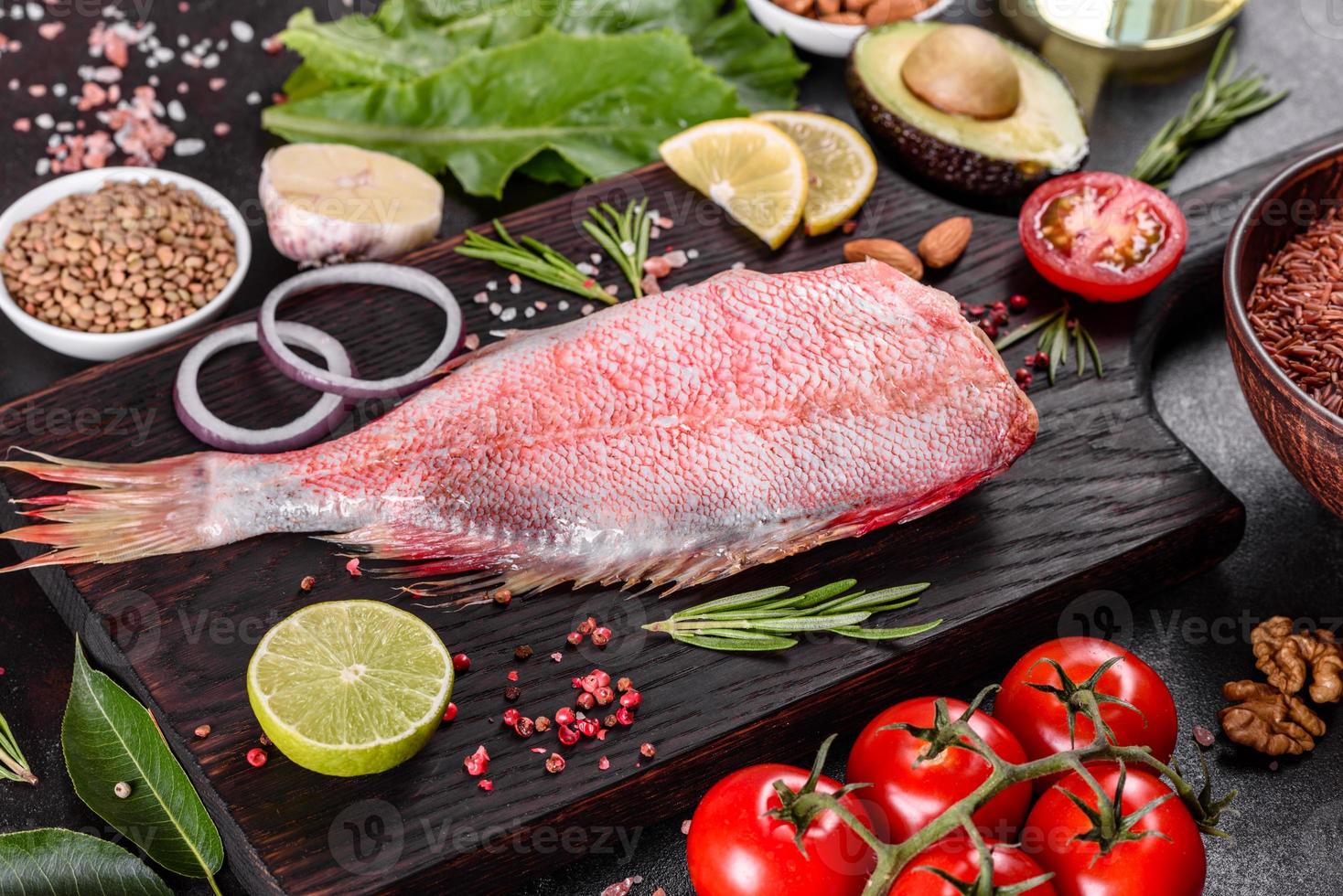 Raw fillet of red sea perch prepared for baking with spices and herbs photo