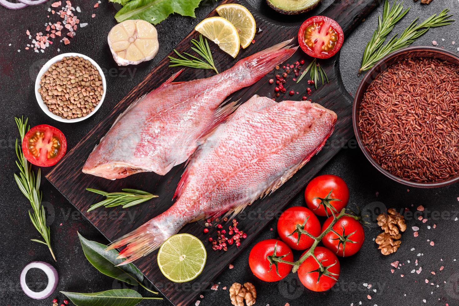 Filete crudo de perca del mar rojo preparado para hornear con especias y hierbas. foto