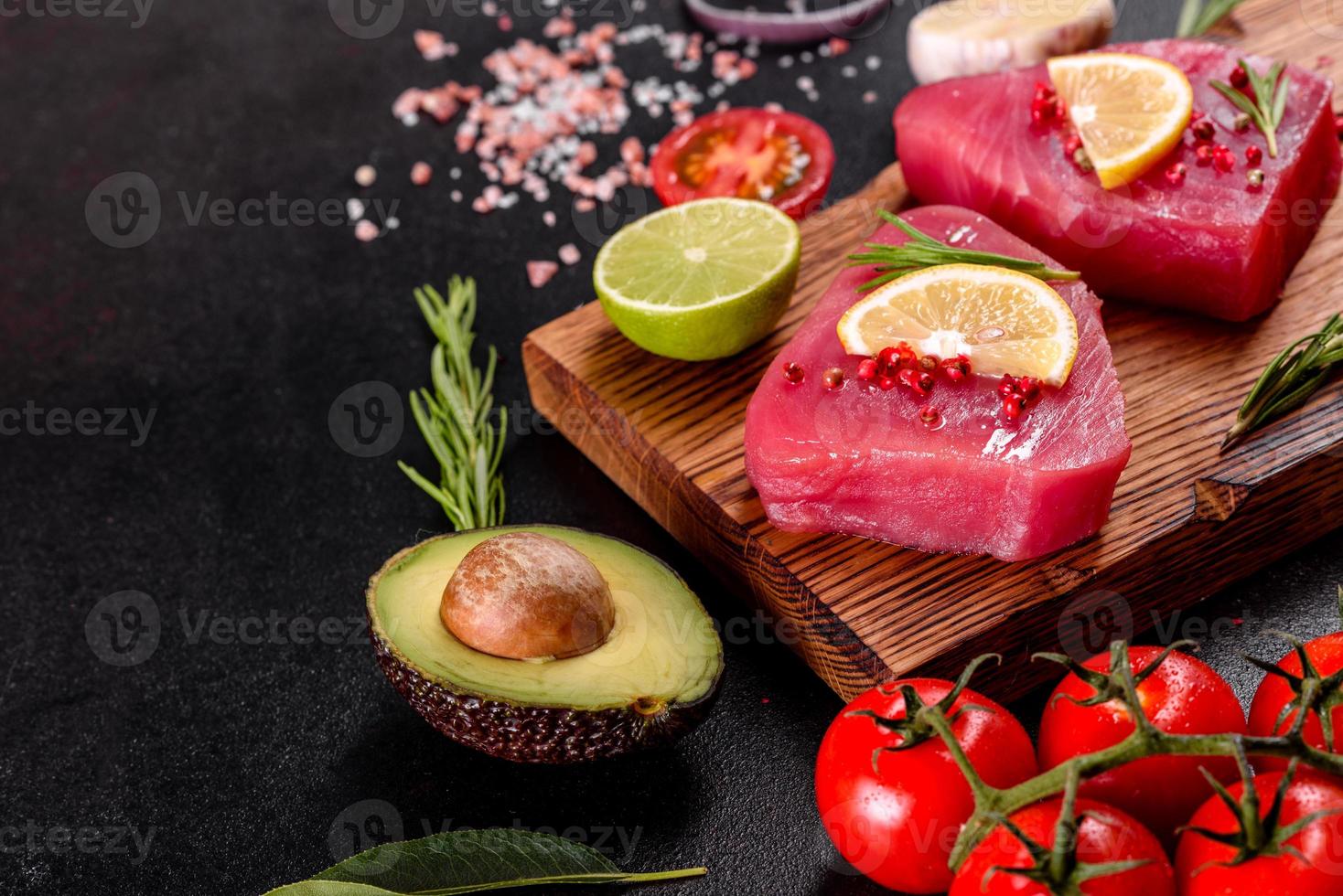 Filetes de atún fresco con especias y hierbas sobre un fondo negro foto