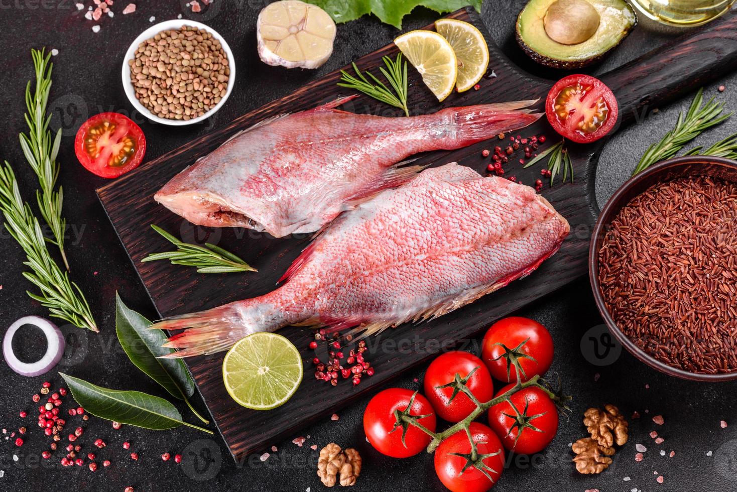 Raw fillet of red sea perch prepared for baking with spices and herbs photo