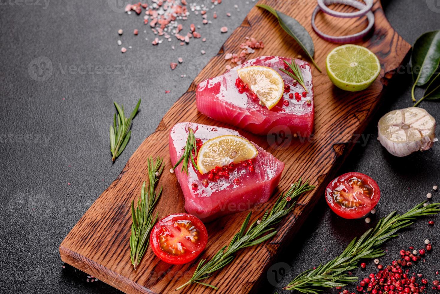 Filetes de atún fresco con especias y hierbas sobre un fondo negro foto